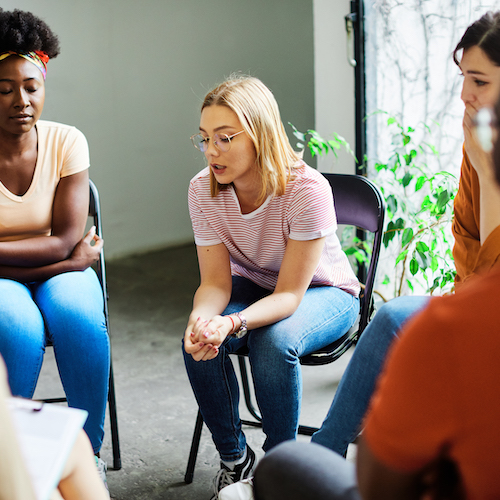 Group psychotherapy. Persons sitting in circle and talking. People meeting. Psychotherapy training, business lecture or conference. Man woman support group