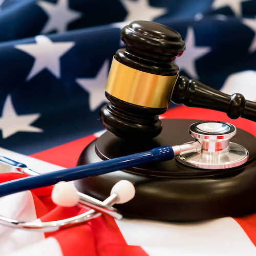Gavel and stethoscope on national flag of USA. Forensic medicine concept